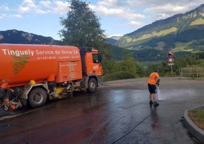 Camion de balayage Tinguely sur route de montagne en Suisse
